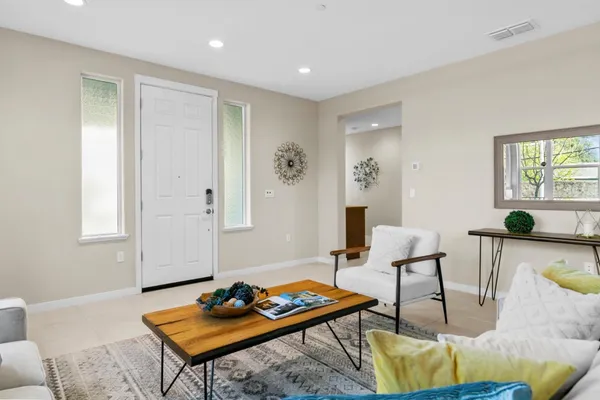 a living room with a wooden floor and potted plant