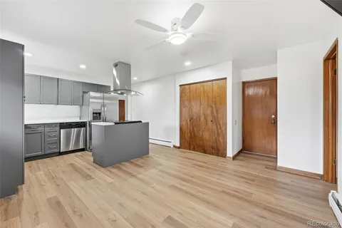 a view of a kitchen with wooden floor and a ceiling fan