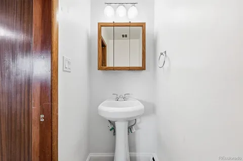 a bathroom with a sink a mirror and a lamp