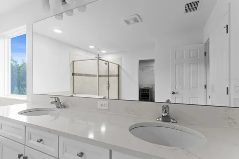 a bathroom with double vanity sinks and a mirror