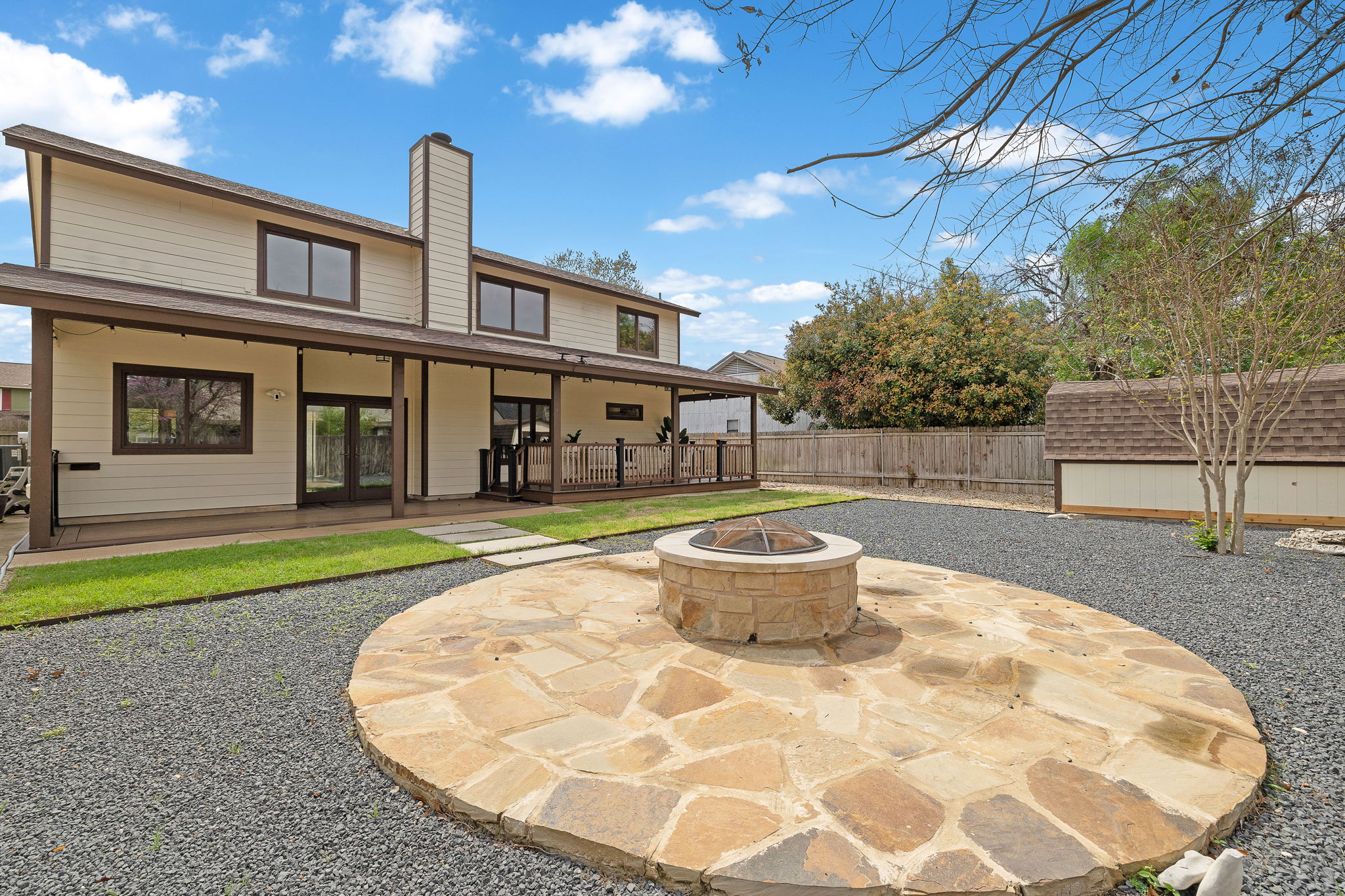 9002 Bancroft Trail Austin, TX 78729 - Photo 5 of 35 Draught-tolerant landscaping in the backyard and a gorgeous fire pit with stone patio seating area.