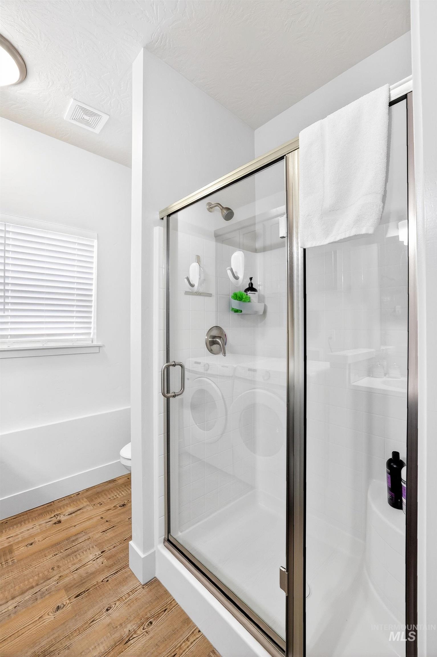 311 Broken Ridge Way McCall, ID 83638 - Photo 18 of 44 Glass-enclosed shower with brushed nickel hardware, white shower base, and integrated shelving