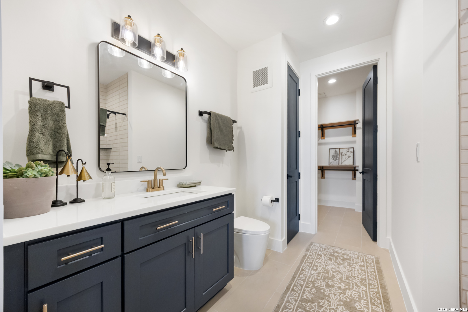 10899 South Hausman Road, Unit 207 San Antonio, TX 78249 - Photo 12 of 24 a bathroom with a sink a toilet and mirror