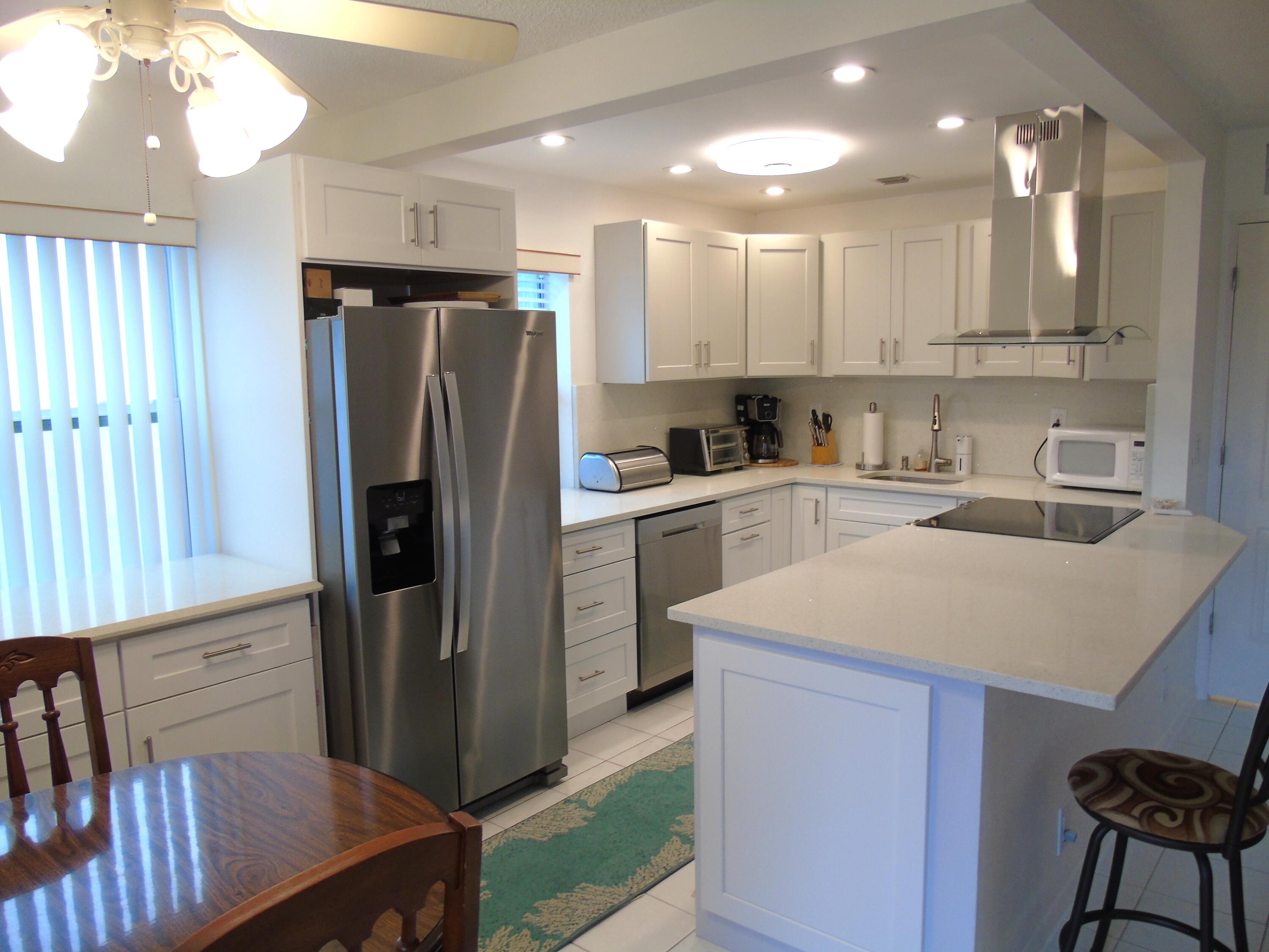 760 Burgundy P Delray Beach, FL 33484 - Photo 4 of 24 a kitchen with a sink a refrigerator and a stove