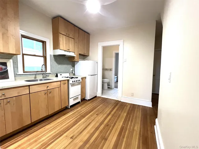 a kitchen with granite countertop white cabinets and white appliances
