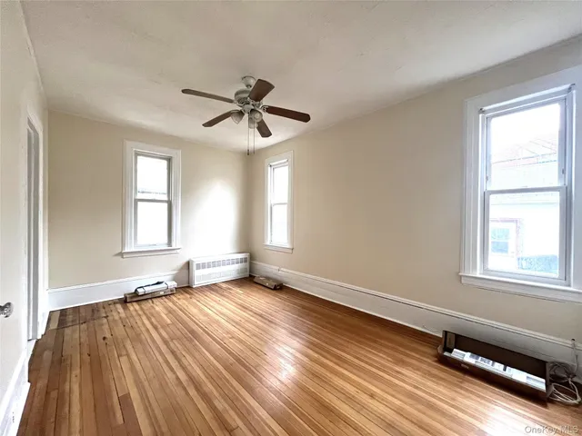 a view of a room with wooden floor and windows