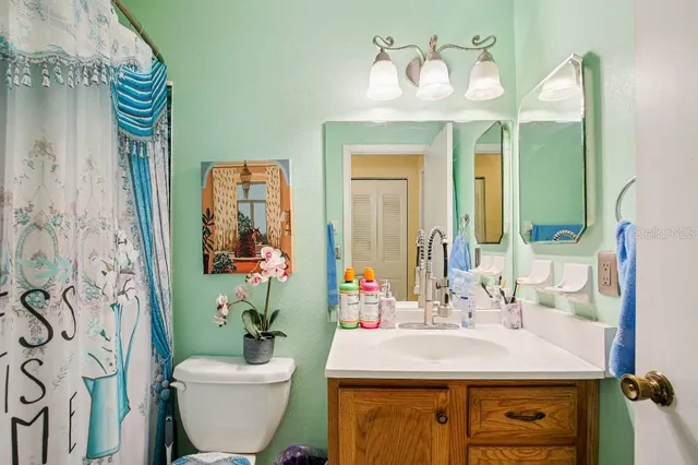 a bathroom with a sink and mirror with toilet