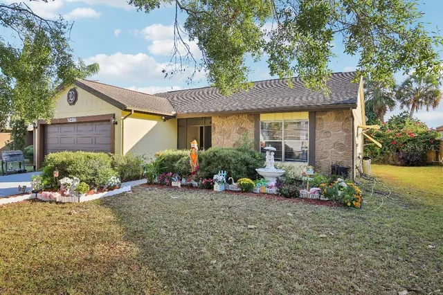 a view of a brick house with potted plants and a bench