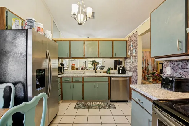a kitchen with stainless steel appliances granite countertop a sink and a refrigerator