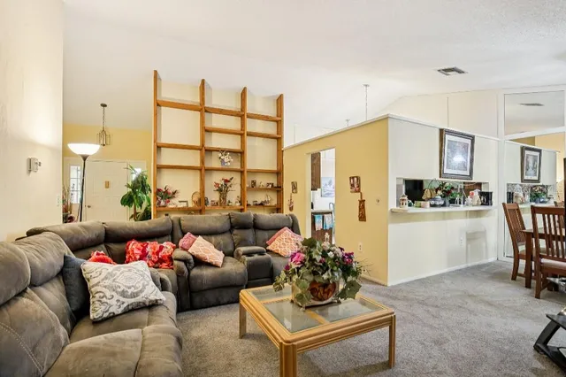 a living room with furniture and kitchen view
