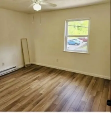 a view of a room with wooden floor and white walls