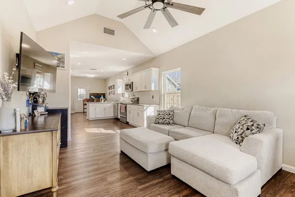 a living room with furniture and a view of kitchen