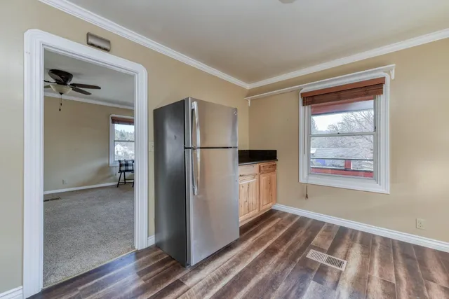 a kitchen with granite countertop a refrigerator stove top oven and sink