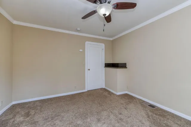 en empty room with ceiling fan and window