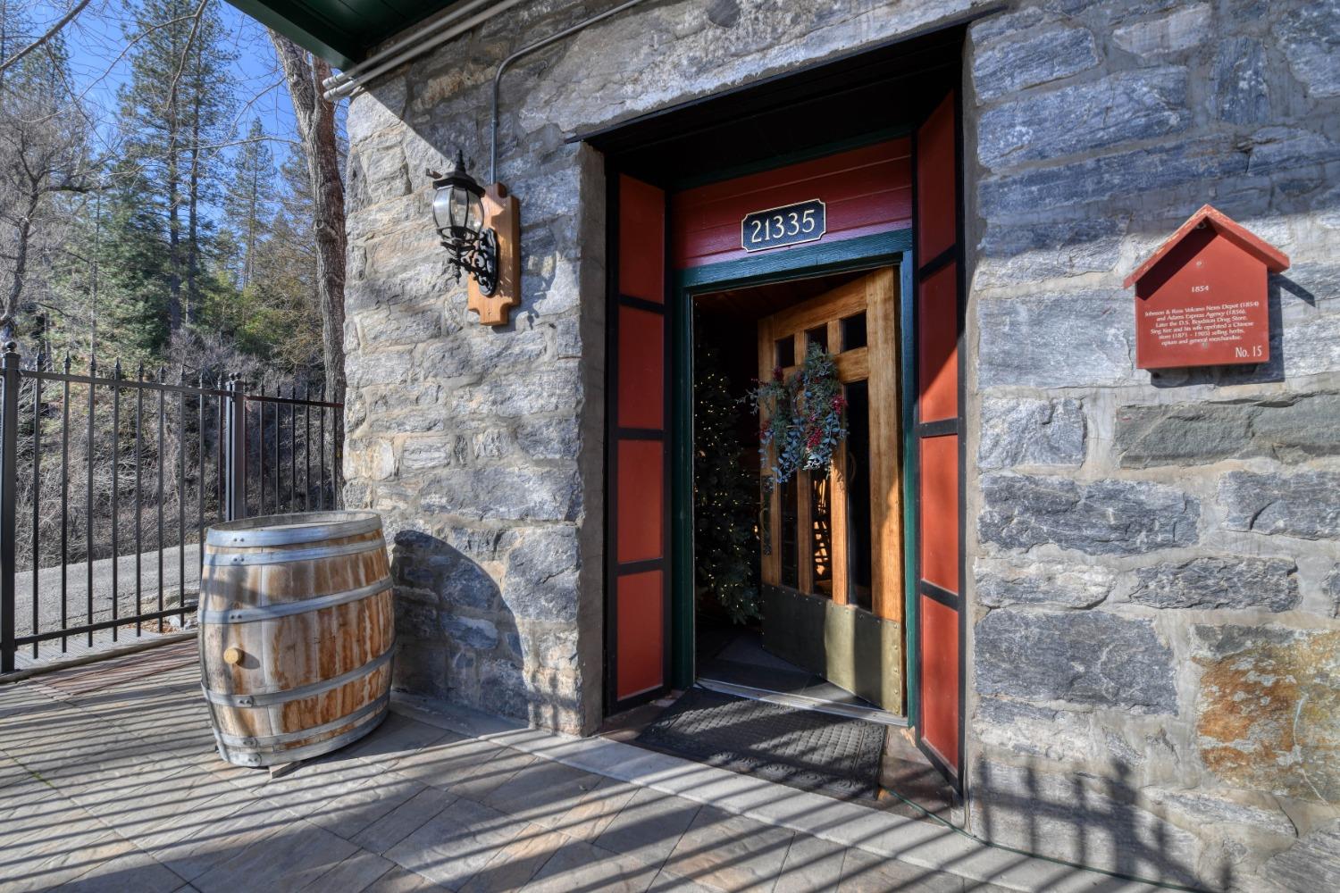 21335 Consolation Street Volcano, CA 95689 - Photo 5 of 41 a view of a brick house with a red door and a potted plant