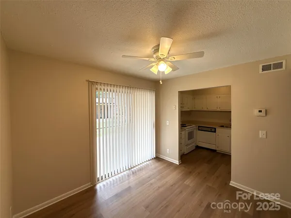 a view of a room with wooden floor and fan