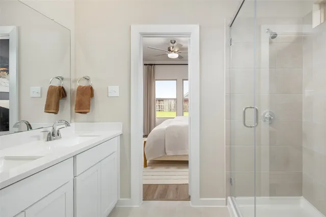 a en suite bathroom with a granite countertop mirror and vanity