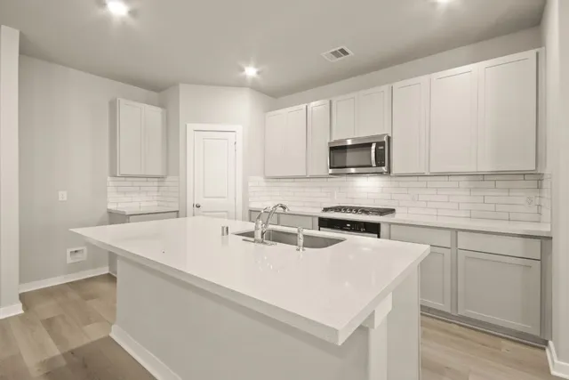a kitchen with a sink a stove and cabinets
