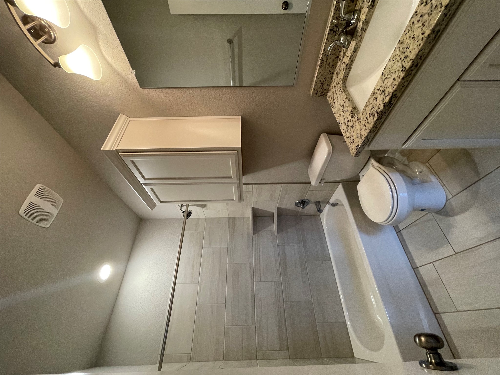 8113 Northgate Loop Temple, TX 76502 - Photo 26 of 35 Full bathroom featuring a tub/shower combination with light-toned tile surround, a built-in shower shelf, a vanity with a granite-style countertop, and a white cabinet base