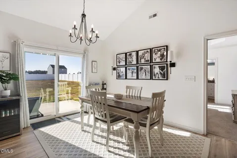 a dining room with furniture a chandelier and wooden floor