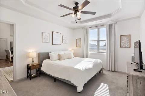 a bedroom with a bed a couch and a flat screen tv