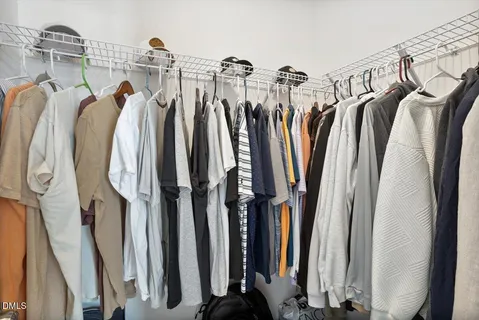 a view of walk in closet with clothes and shoes