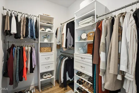 a view of walk in closet with clothes and shoes