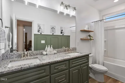 a bathroom with a granite countertop sink toilet a large mirror and shower