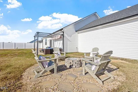 a view of a patio with table and chairs and floor to ceiling window