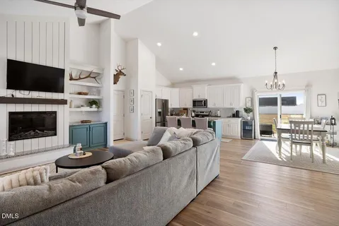 a living room with furniture a flat screen tv and a fireplace