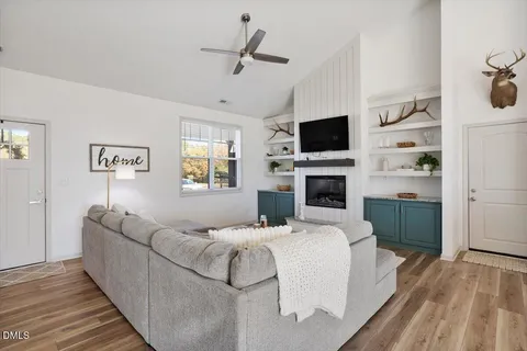 a living room with furniture a flat screen tv and a fireplace