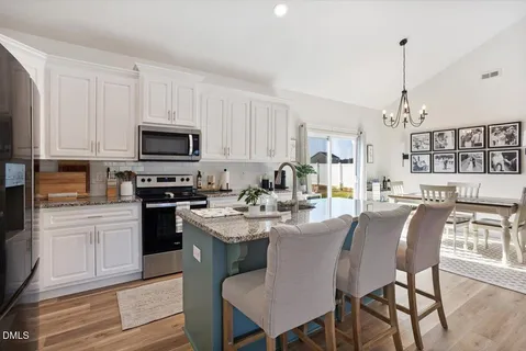a view of kitchen with sink dining table and chairs