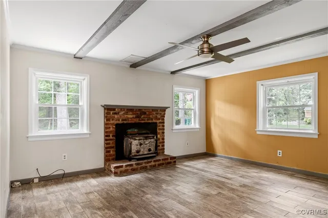 an empty room with windows and fireplace