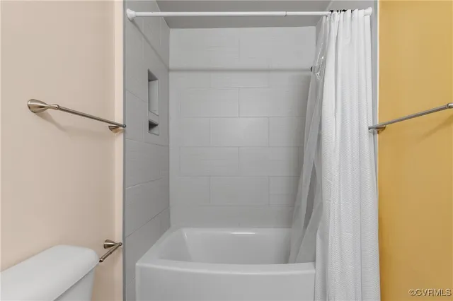 a white bath tub sitting next to a shower