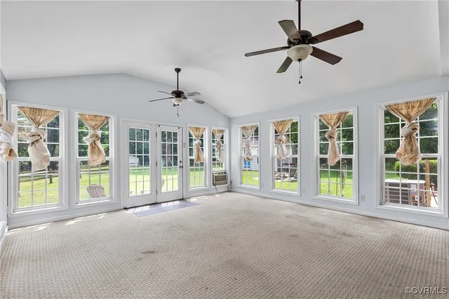 a view of an empty room with a window and ceiling fan