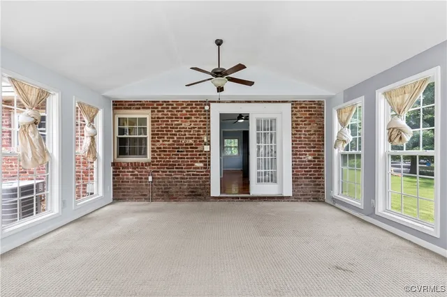 a view of a livingroom with a ceiling fan and windows