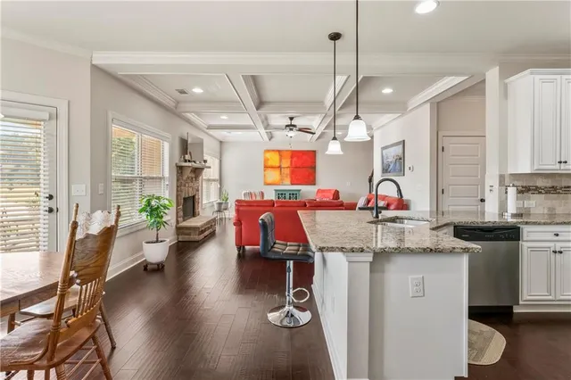 a view of a kitchen with sink microwave and wooden floor
