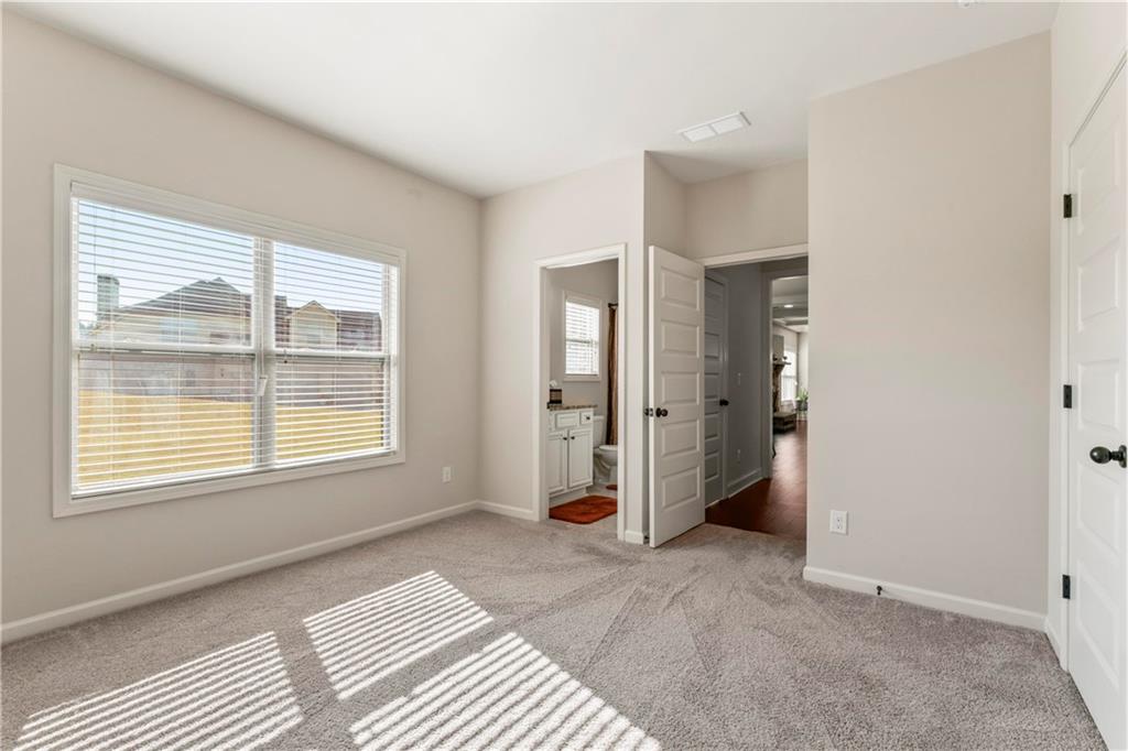7004 Becca Lane Locust Grove, GA 30248 - Photo 18 of 39 a spacious bedroom with a bed and a window