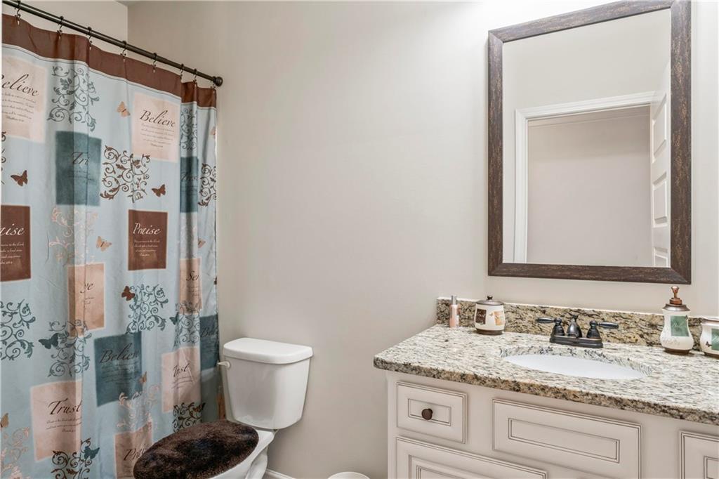 7004 Becca Lane Locust Grove, GA 30248 - Photo 22 of 39 a bathroom with a granite countertop sink a toilet and a mirror