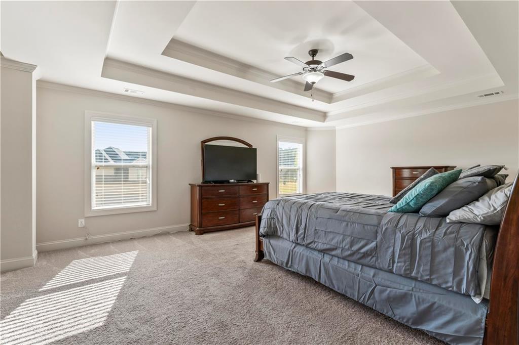 7004 Becca Lane Locust Grove, GA 30248 - Photo 25 of 39 a living room with a bed furniture and a chandelier