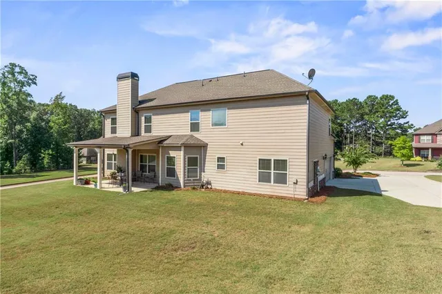 a view of a house with a yard and sitting area