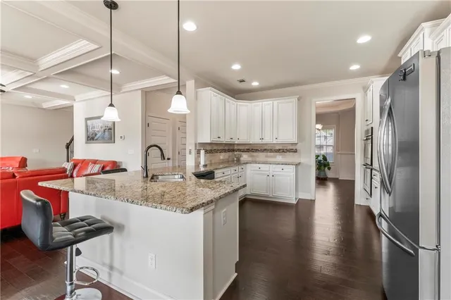 a kitchen with stainless steel appliances granite countertop a sink refrigerator and cabinets