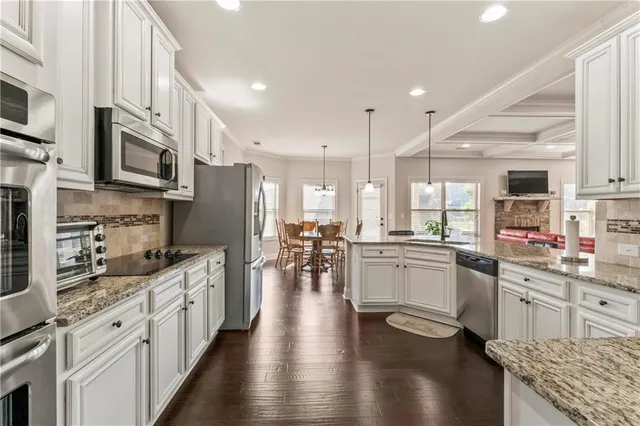 a kitchen with lots of counter top space a sink appliances and cabinets