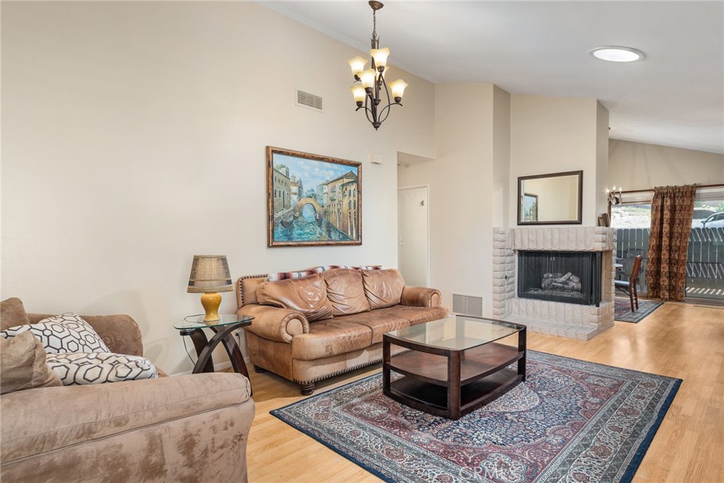1400 Market Street Vista, CA 92084 - Photo 5 of 31 a living room with furniture a chandelier and a fireplace