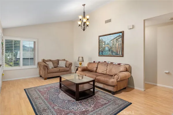a living room with furniture a flat screen tv and a floor to ceiling window