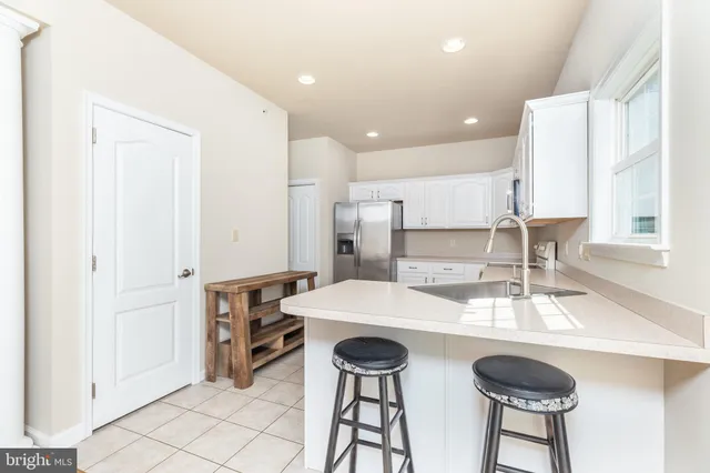 a kitchen with a sink and chairs