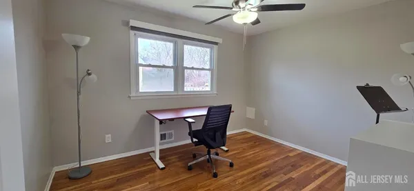 a view of a workspace with furniture and a window