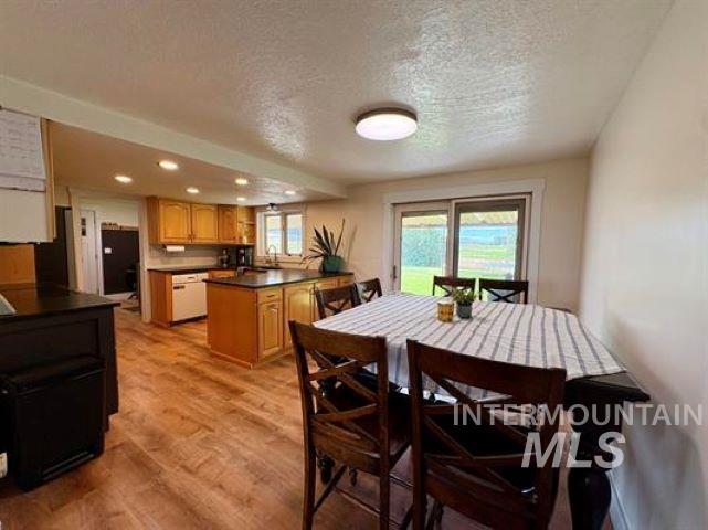 3197 Neeley Road American Falls, ID 83211 - Photo 4 of 45 Open-concept kitchen and dining area featuring wood-finish flooring, recessed lighting, light-toned cabinetry, and a central island with a dark countertop