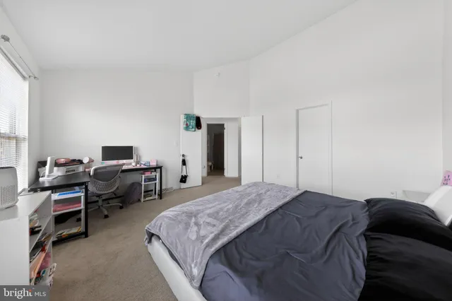 a bedroom with a bed and a computer on the desk