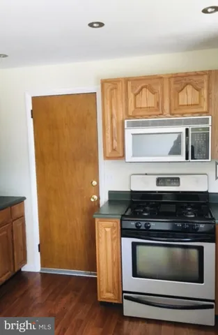 a kitchen with granite countertop white cabinets and black appliances